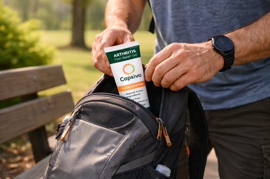 Person slipping a Capsiva gel tube into a small daypack before a walk, with sunlight on a park bench and no text overlays.